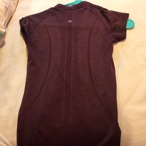 A maroon Lululemon size four shirt form fitting.